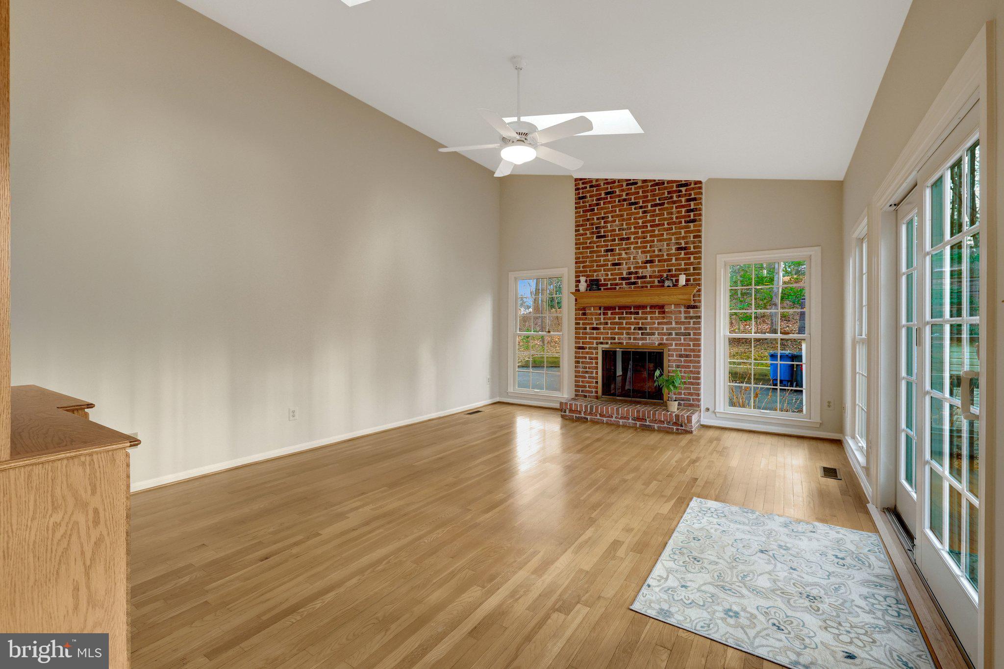 11273 Waples Mill Road Oakton, VA 22124 - Photo 47 of 75 an empty room with wooden floor fireplace and windows