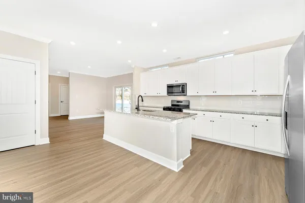 a view of kitchen with stainless steel appliances refrigerator oven and cabinets