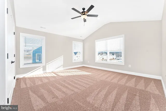 an empty room with ceiling fan and window