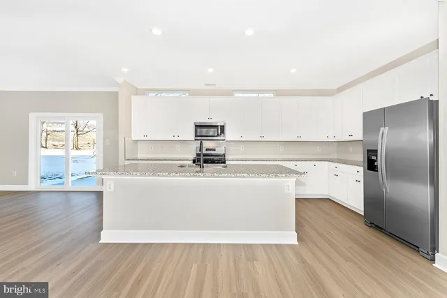 a view of kitchen with stainless steel appliances granite countertop a stove a sink and a refrigerator