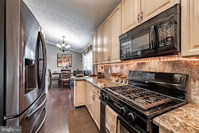 a kitchen with stainless steel appliances granite countertop a stove top oven microwave and refrigerator