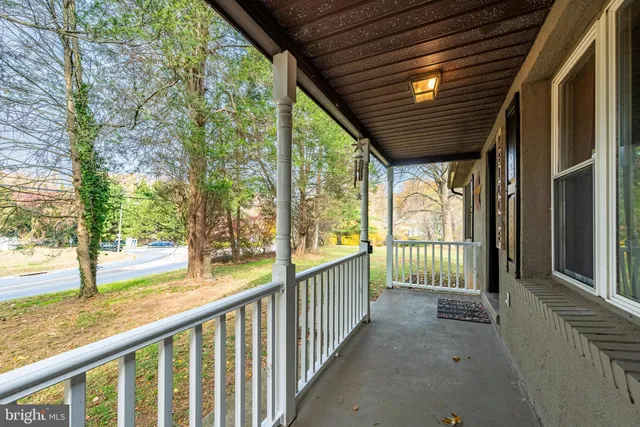 a view of porch with green trees in front of main door