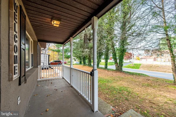 a view of a porch with wooden floor and roof with a garden view