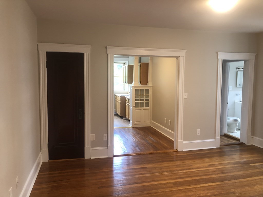 an empty room with wooden floor & windows