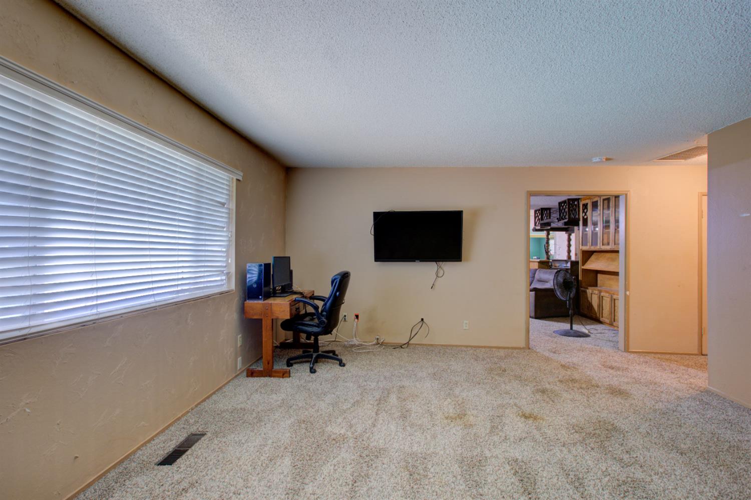 2982 Sequoia Drive Merced, CA 95340 - Photo 22 of 33 a view of a livingroom with a chair and a flat screen tv