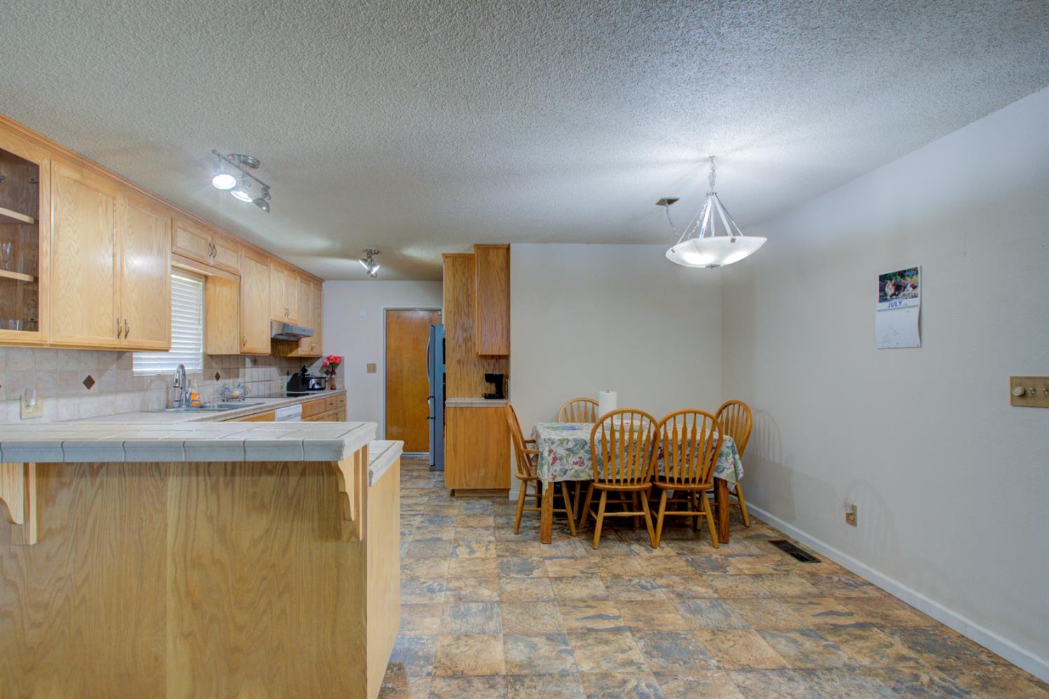 2982 Sequoia Drive Merced, CA 95340 - Photo 9 of 33 a living room with furniture a chandelier and kitchen view