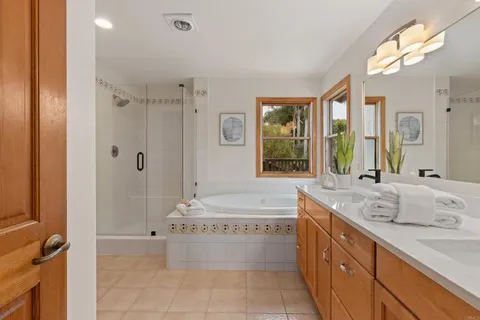 a bathroom with a granite countertop sink a large mirror and a bathtub