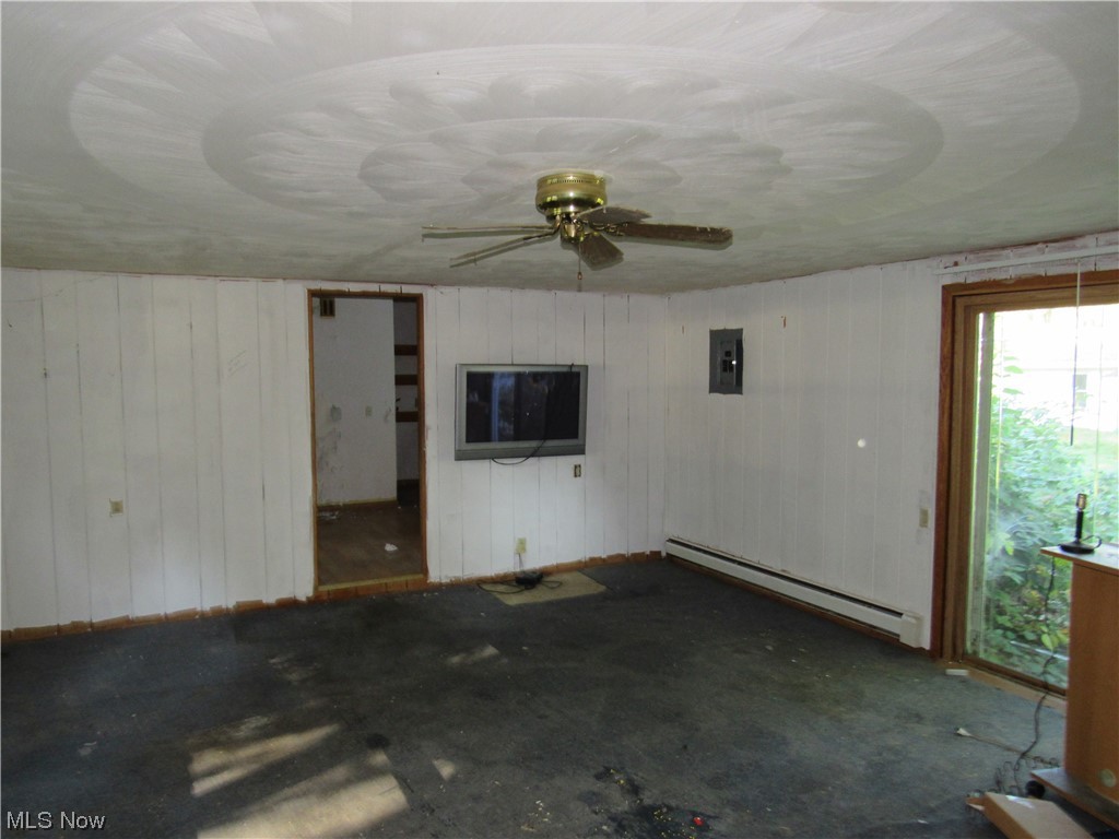 6986 Reed Road Conneaut, OH 44030 - Photo 5 of 22 Unfurnished room featuring a baseboard radiator and ceiling fan