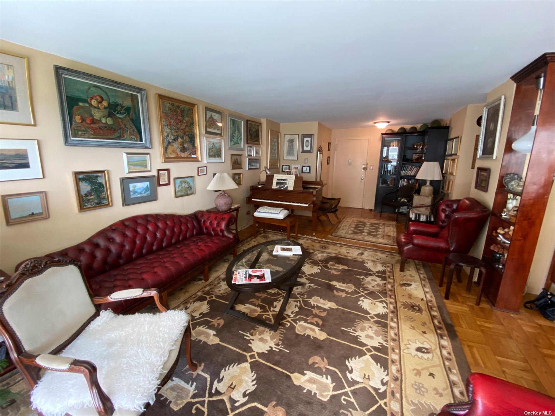 a living room with furniture a couch and paintings on the wall