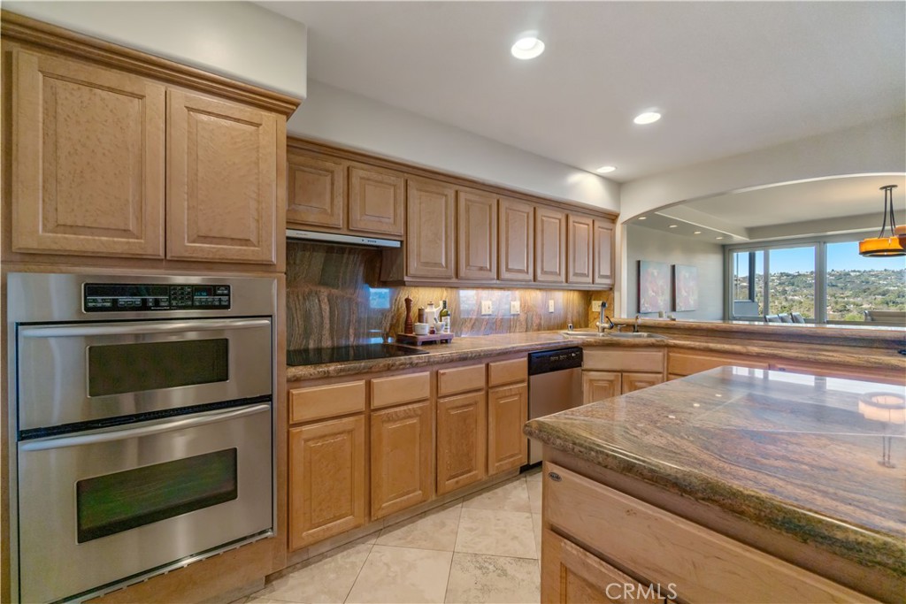 875 Comstock Avenue, Unit 16A Los Angeles, CA 90024 - Photo 13 of 28 a kitchen with granite countertop wooden cabinets stainless steel appliances and a window