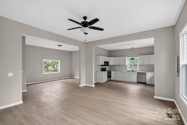 a view of a kitchen with wooden floor a sink and a window