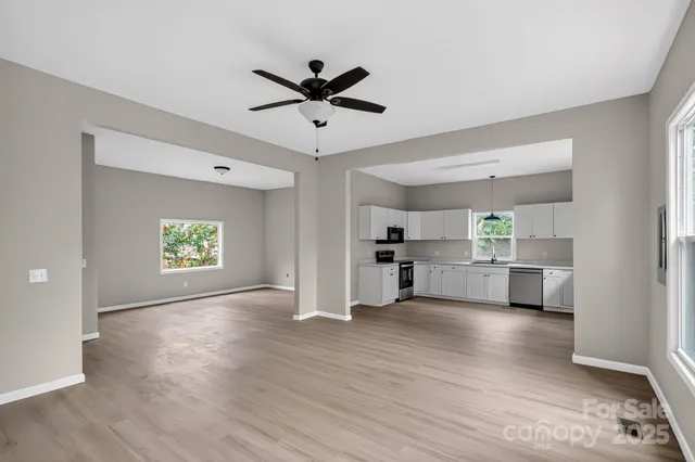 a view of a kitchen with wooden floor a sink and a window