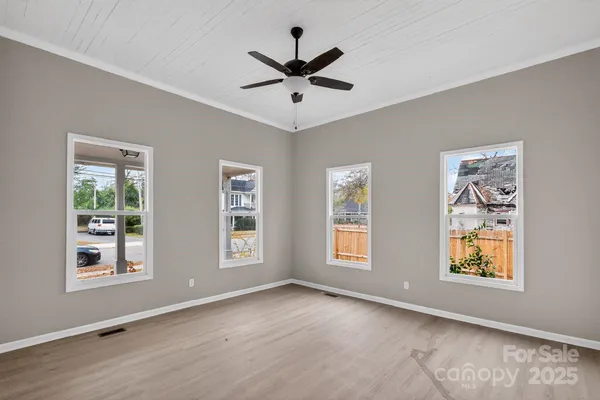 an empty room with window and ceiling fan