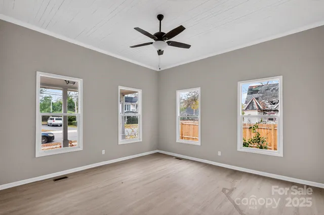 an empty room with window and ceiling fan