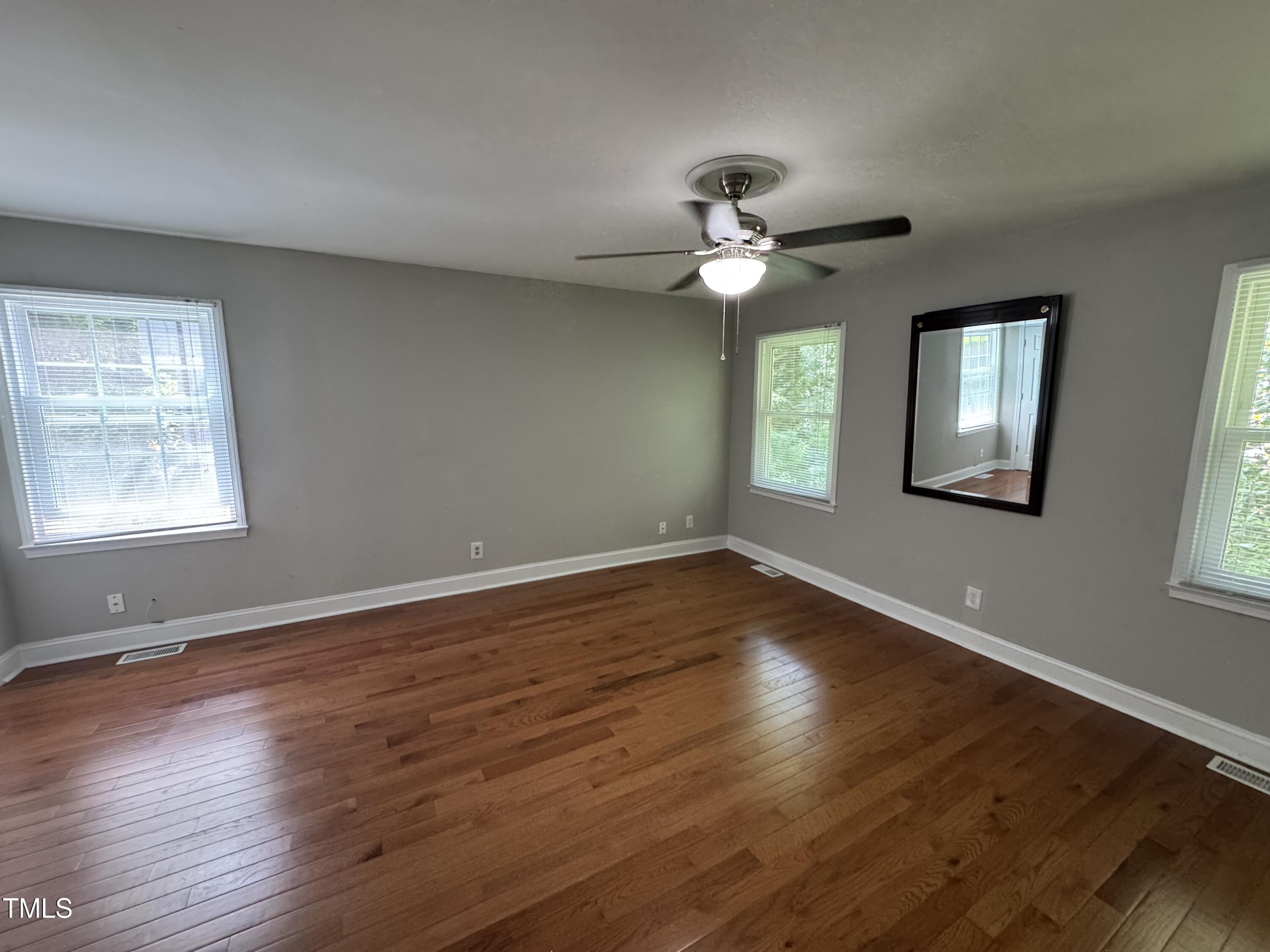 1513 Shelley Road Raleigh, NC 27612 - Photo 13 of 24 a view of an empty room with wooden floor and a window