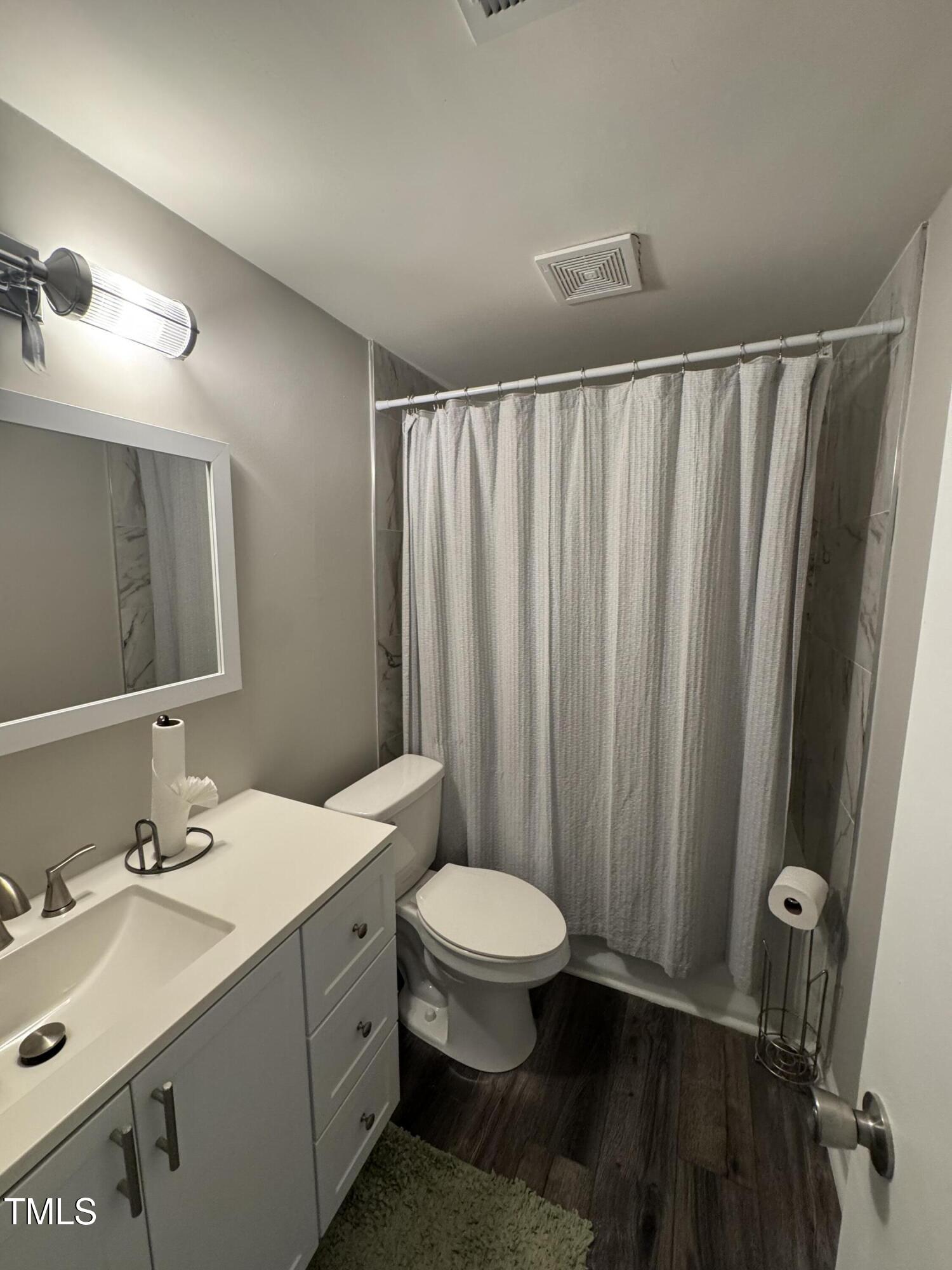 1513 Shelley Road Raleigh, NC 27612 - Photo 15 of 24 a bathroom with a double vanity sink toilet and a mirror