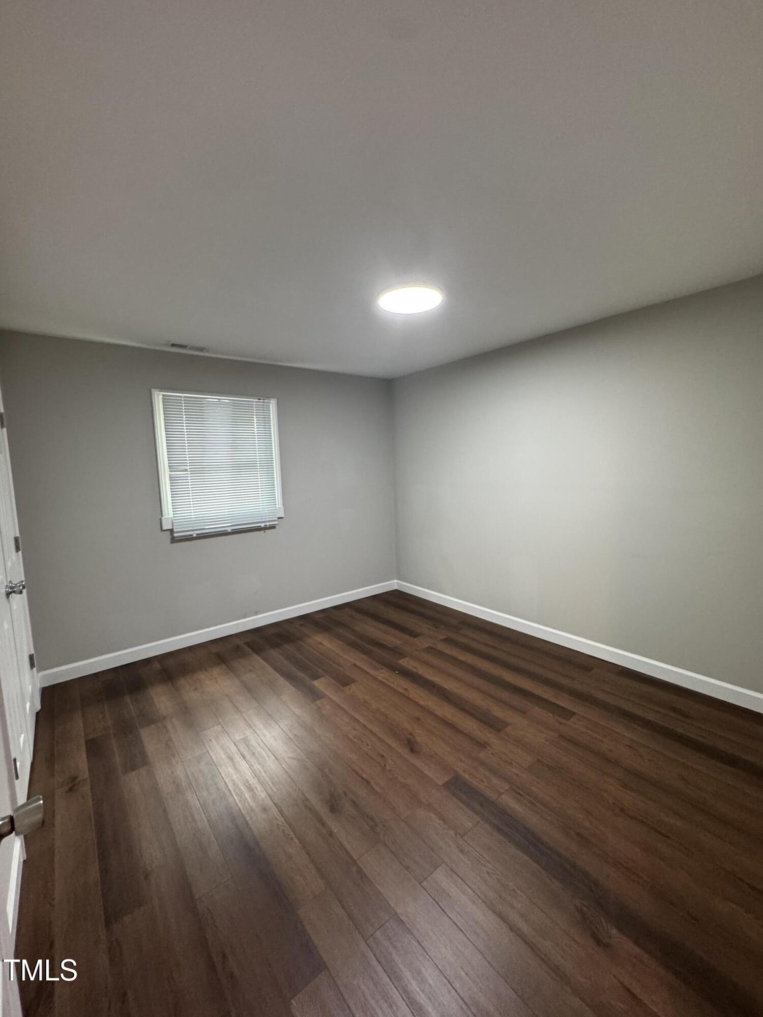 1513 Shelley Road Raleigh, NC 27612 - Photo 16 of 24 a view of an empty room with wooden floor and a window