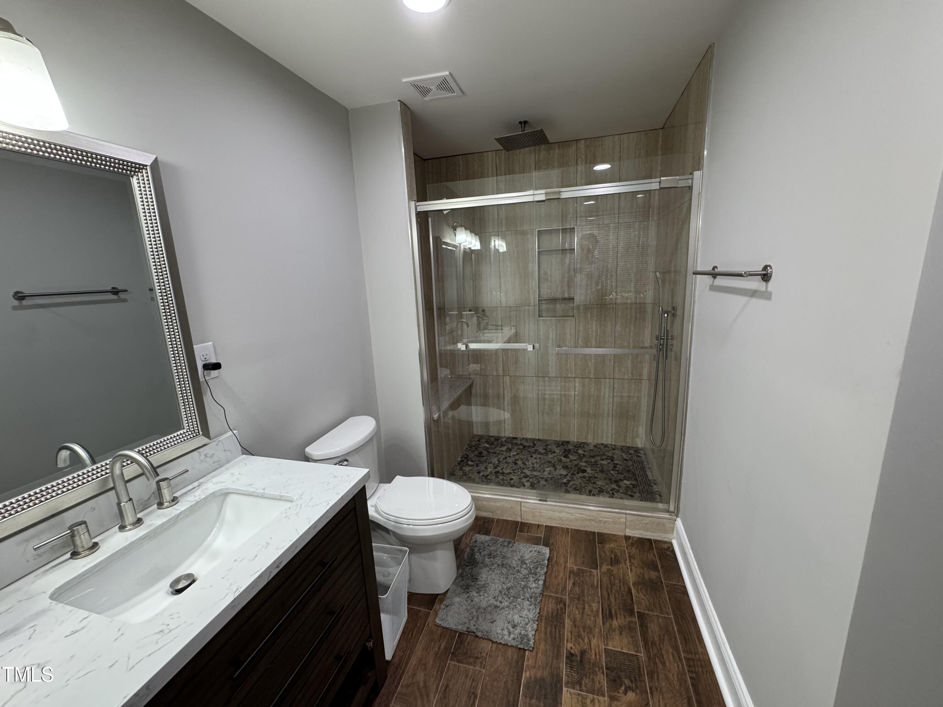 1513 Shelley Road Raleigh, NC 27612 - Photo 20 of 24 a bathroom with a sink toilet a mirror and shower