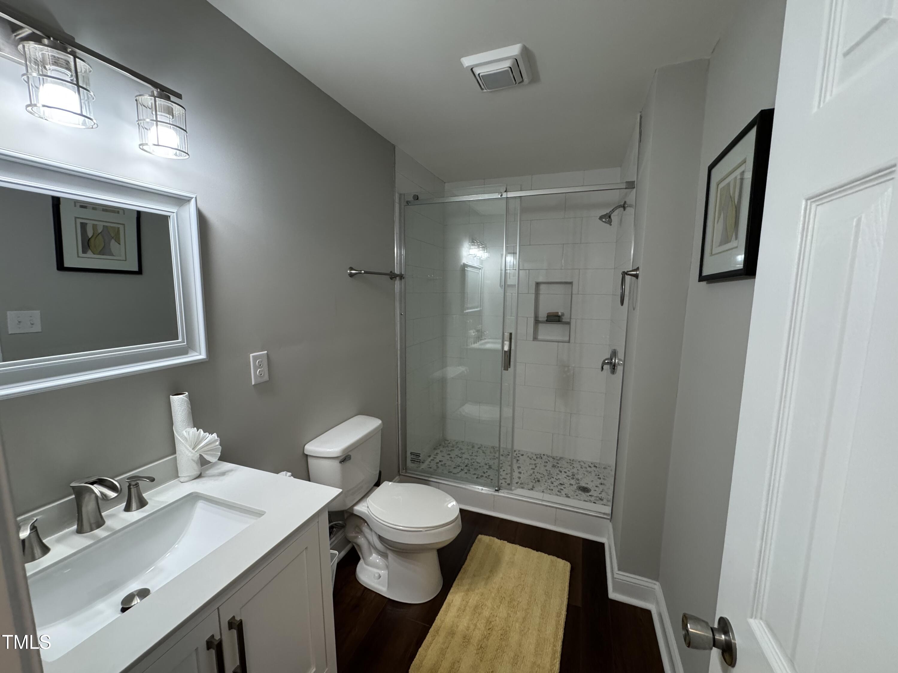 1513 Shelley Road Raleigh, NC 27612 - Photo 21 of 24 a bathroom with a sink toilet a mirror and shower