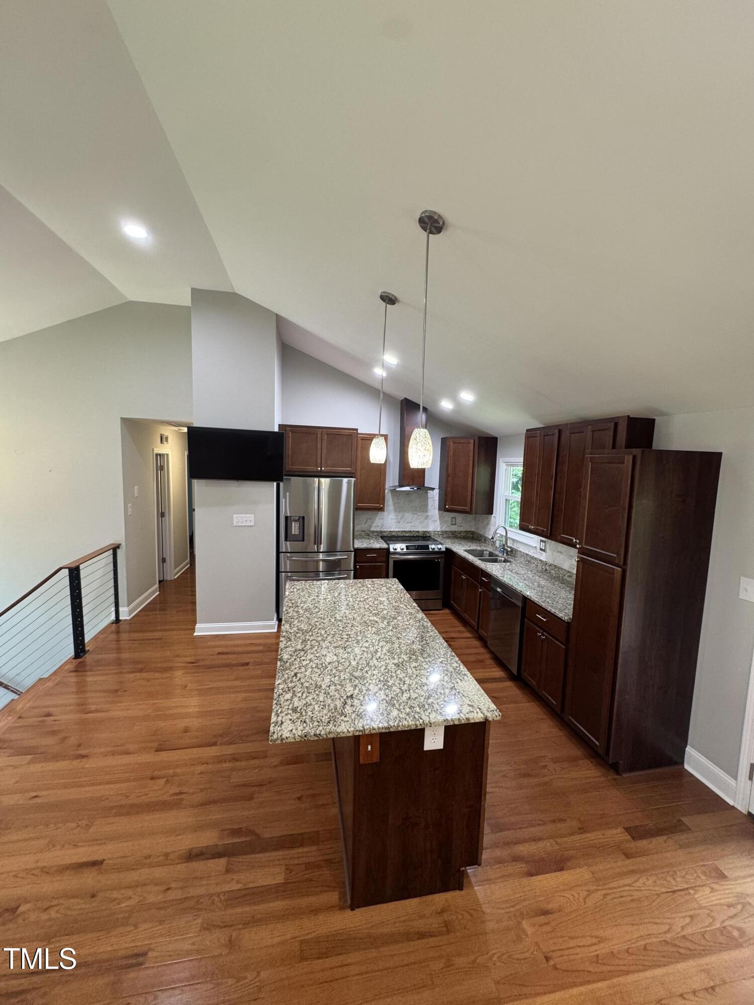 1513 Shelley Road Raleigh, NC 27612 - Photo 7 of 24 a large kitchen with stainless steel appliances kitchen island a large counter top and wooden floor
