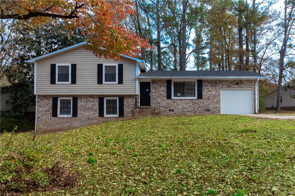 a front view of house with yard and trees