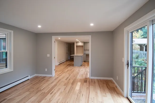 a view of a room with wooden floor and a window