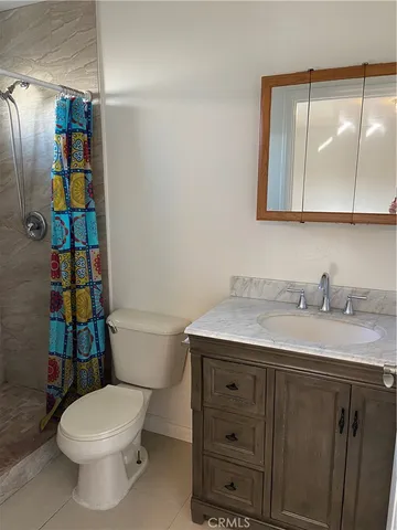 a bathroom with a granite countertop toilet sink and mirror