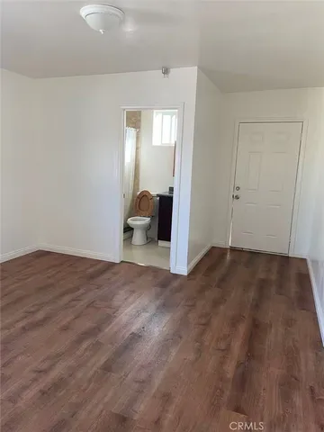 a view of a room with wooden floor and bathroom