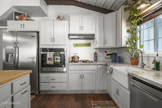 a kitchen with granite countertop white cabinets and white appliances