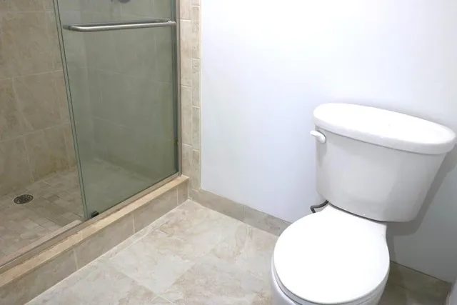 a bathroom with a toilet and a shower