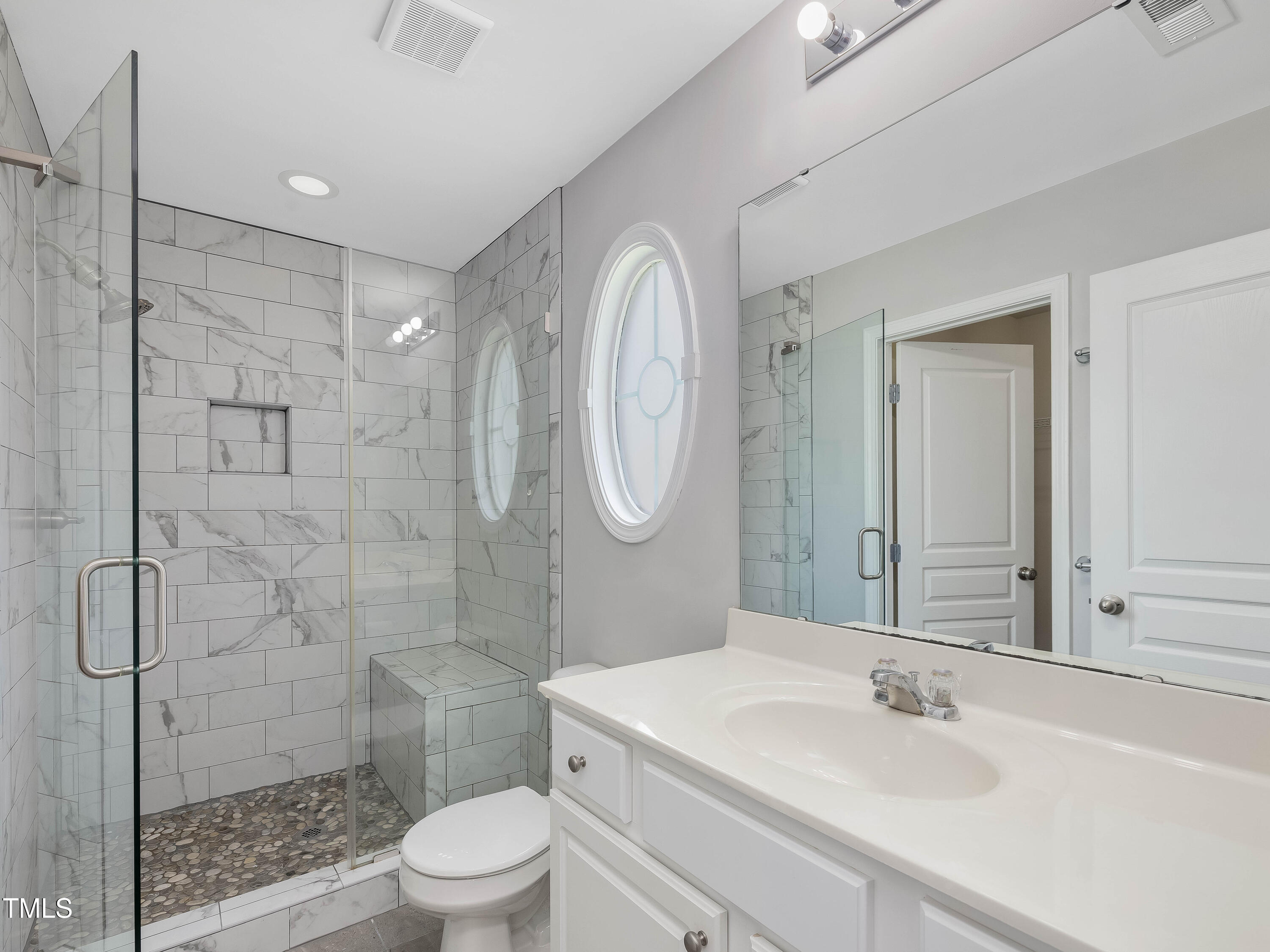 7661 Winners Edge Street Raleigh, NC 27617 - Photo 10 of 13 a bathroom with a sink toilet a mirror and shower