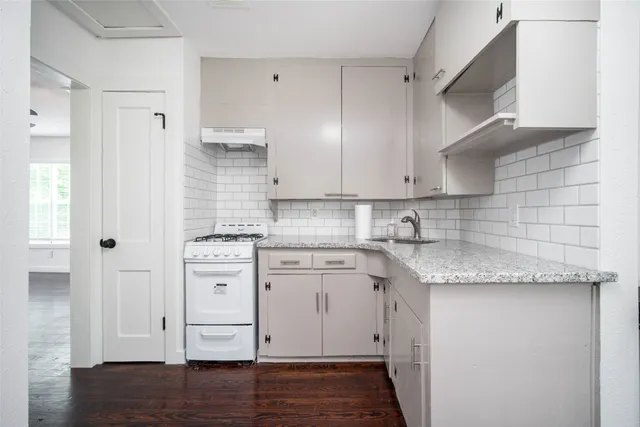 a kitchen with granite countertop white cabinets and white appliances