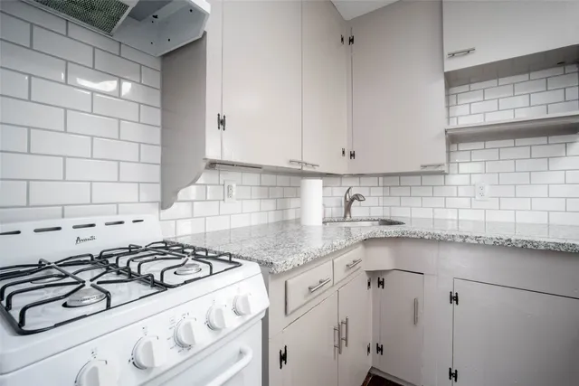 a kitchen with granite countertop a sink stove and cabinets