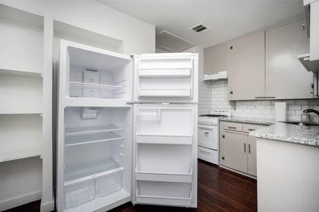 a kitchen with granite countertop cabinets and appliances