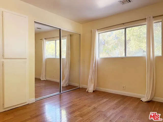an empty room with wooden floor and a window