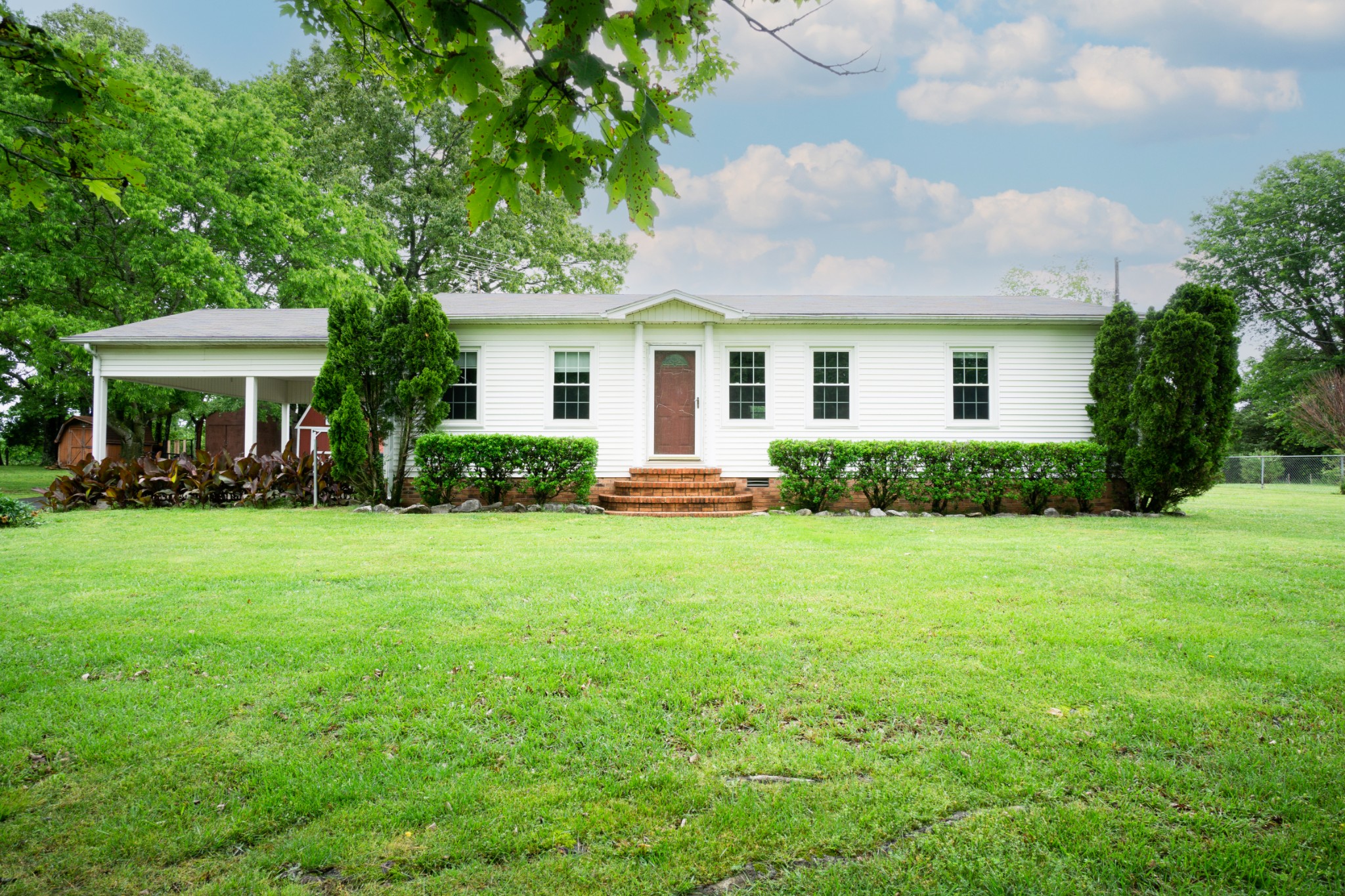 a front view of house with yard and green space