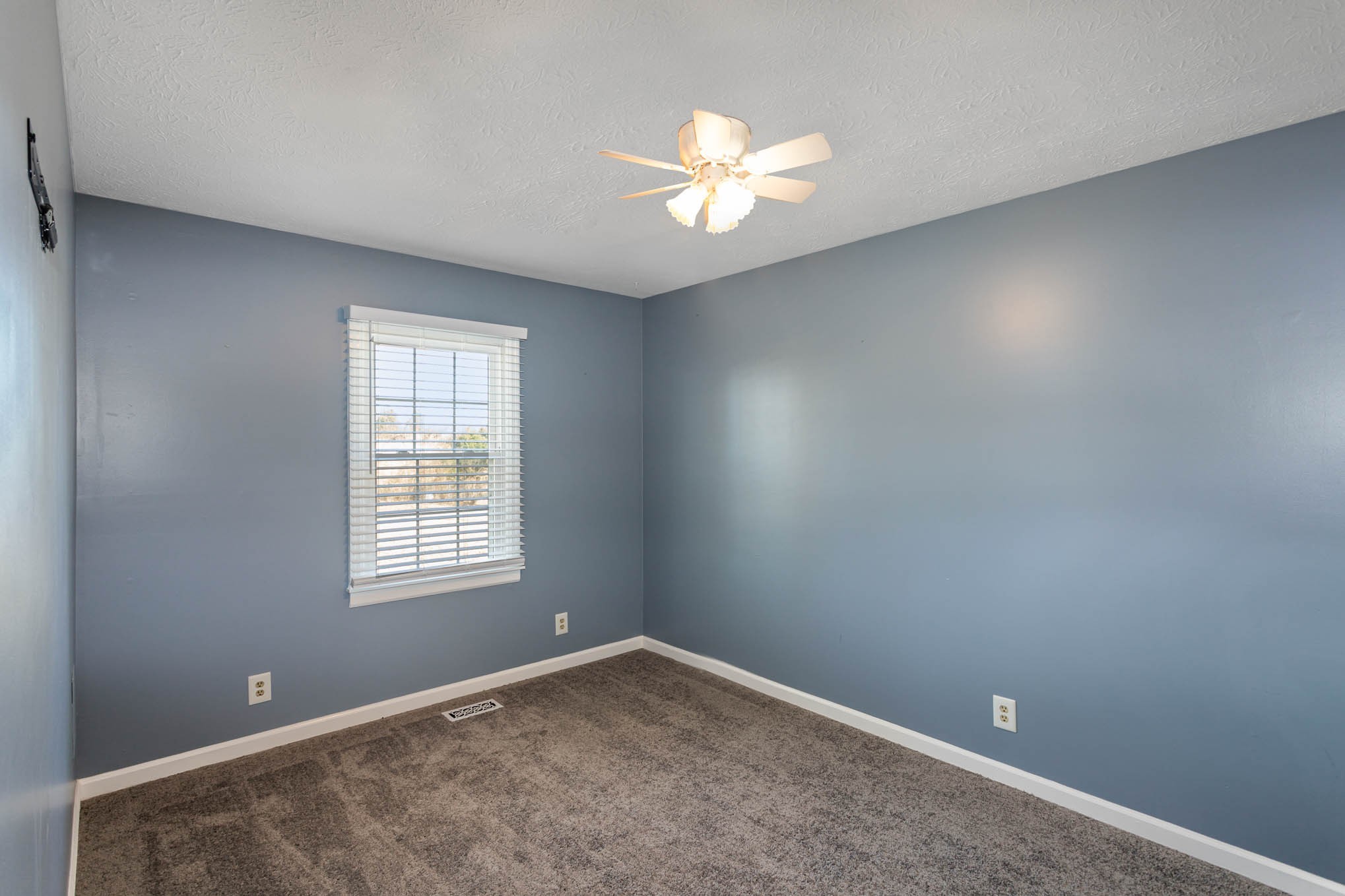 1035 Garton Road Burns, TN 37029 - Photo 22 of 31 an empty room with windows and chandelier fan