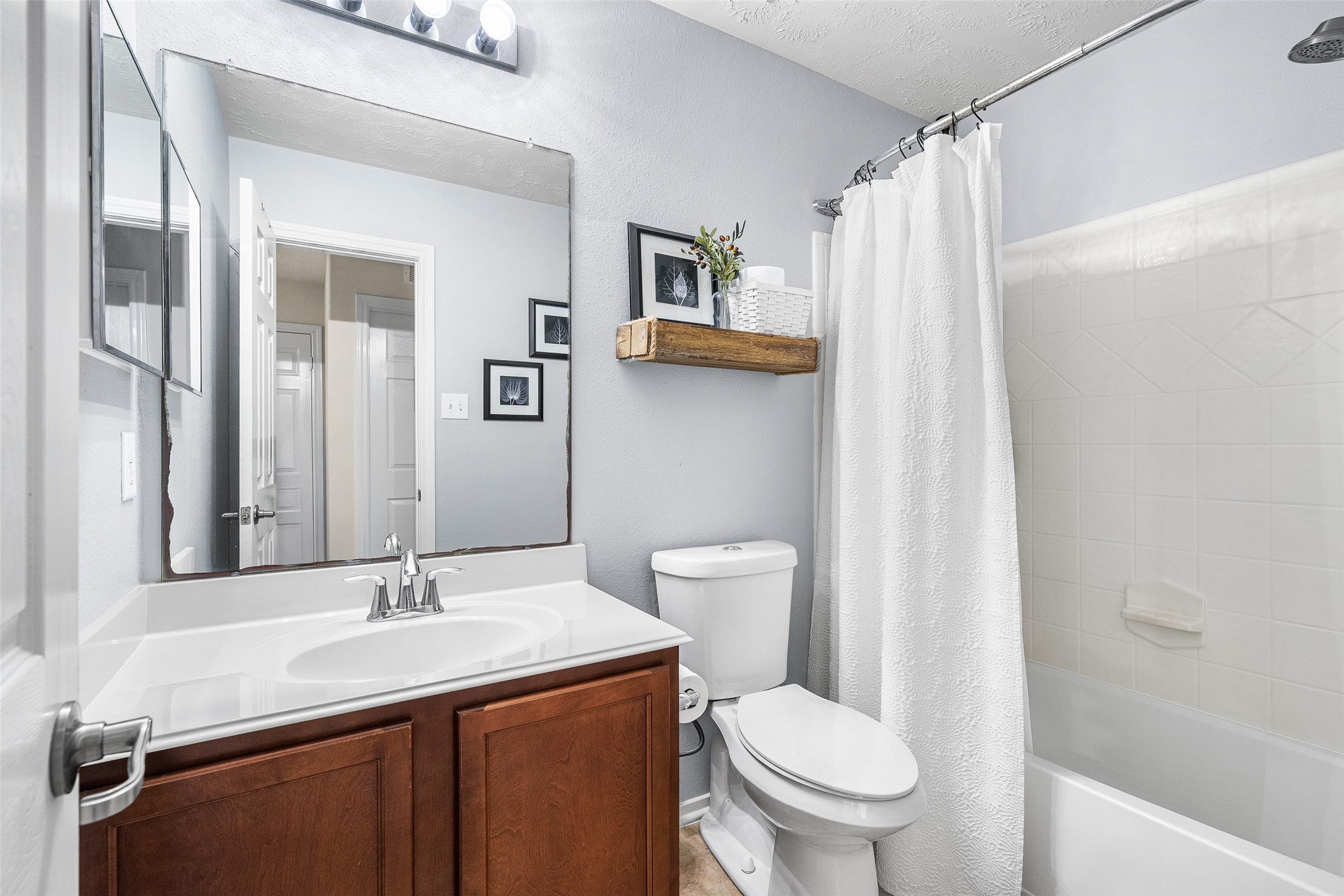 267 Bloomhill Place Magnolia, TX 77354 - Photo 13 of 19 This bathroom features a single-sink vanity, a toilet, and a shower/tub combo, offering a clean, functional design with everyday comfort in mind.