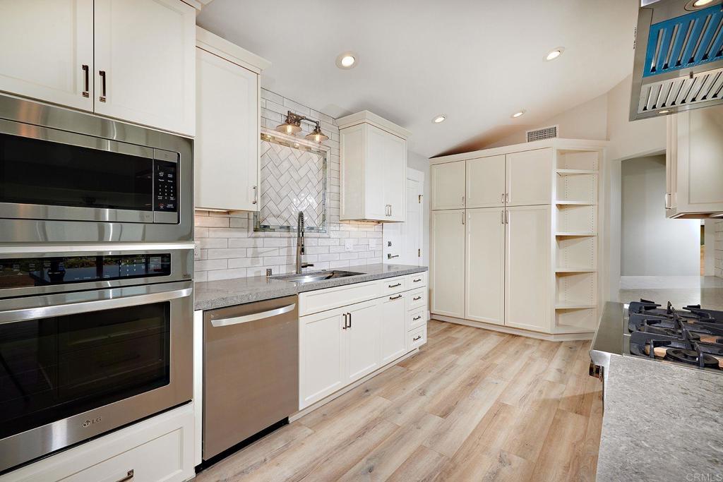 717 Barbara Avenue Solana Beach, CA 92075 - Photo 26 of 40 a kitchen with stainless steel appliances granite countertop a stove a sink and a refrigerator