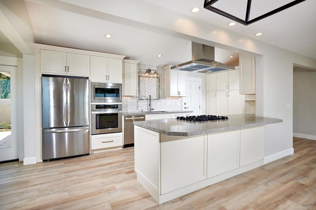 717 Barbara Avenue Solana Beach, CA 92075 - Photo 27 of 40 a kitchen with stainless steel appliances granite countertop a stove a refrigerator and a microwave