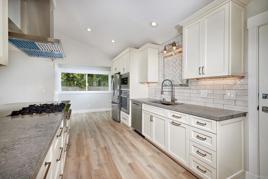 717 Barbara Avenue Solana Beach, CA 92075 - Photo 28 of 40 a kitchen with stainless steel appliances a sink dishwasher stove refrigerator and cabinets