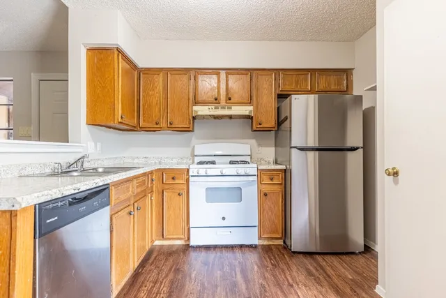 a kitchen with stainless steel appliances granite countertop a refrigerator sink and cabinets