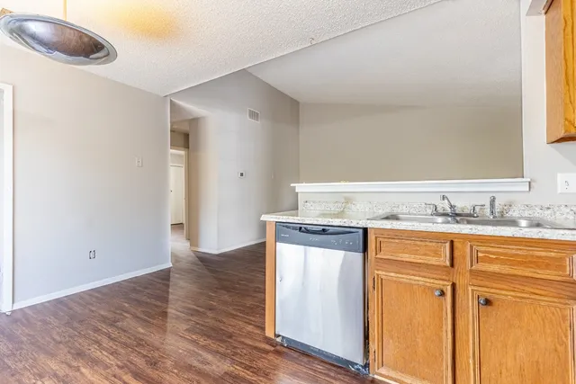 a view of a kitchen with granite countertop cabinets and wooden floor