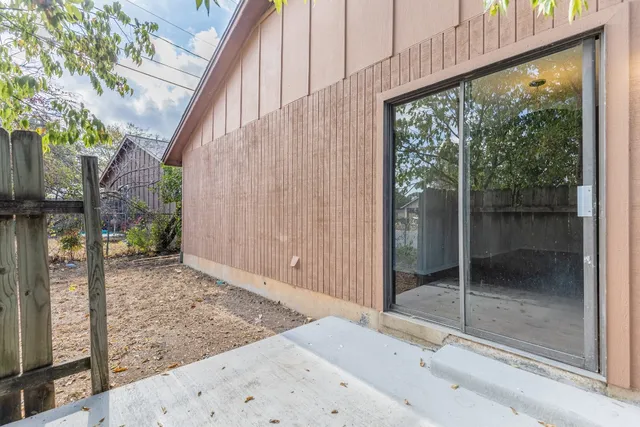 a backyard of a house with a fountain and bench