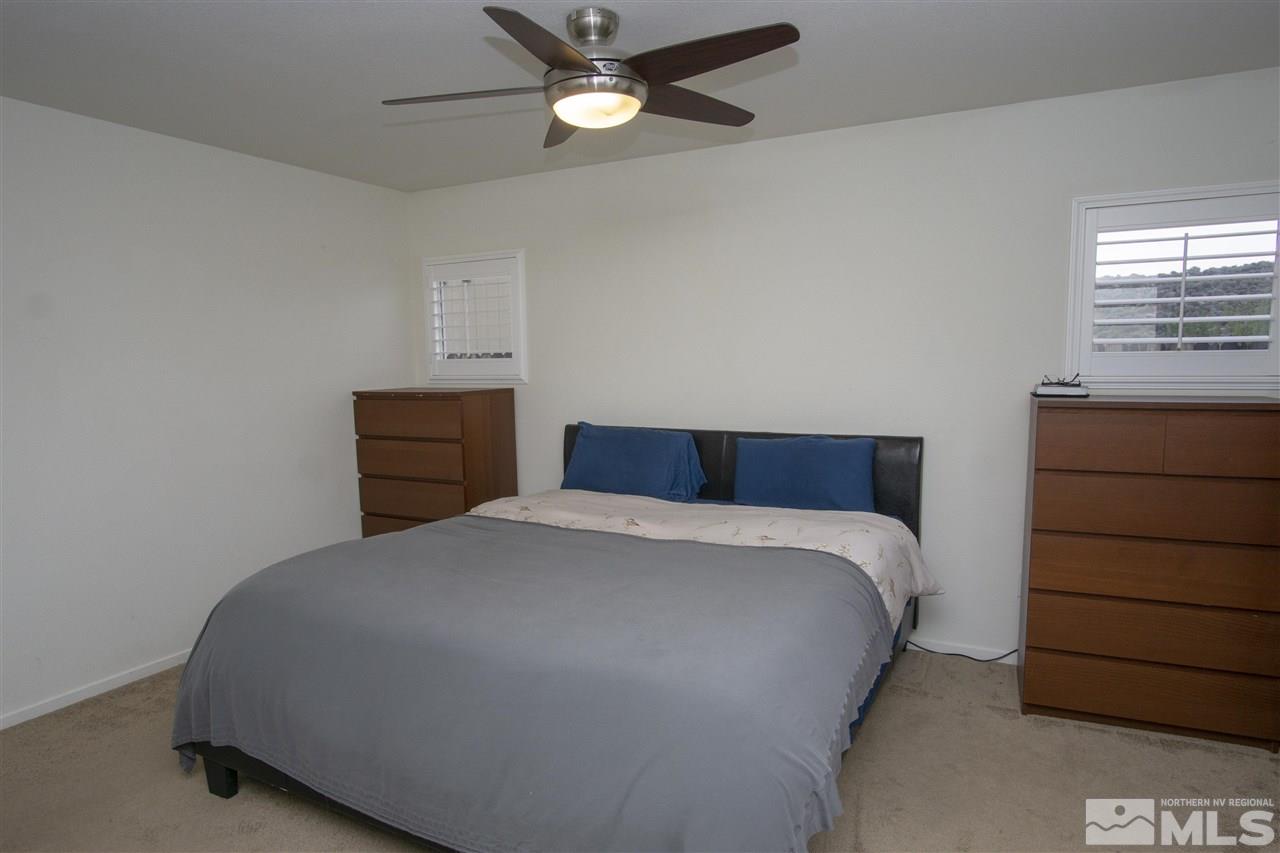 7692 Corso Street Reno, NV 89506 - Photo 12 of 23 a bedroom with a bed and a ceiling fan