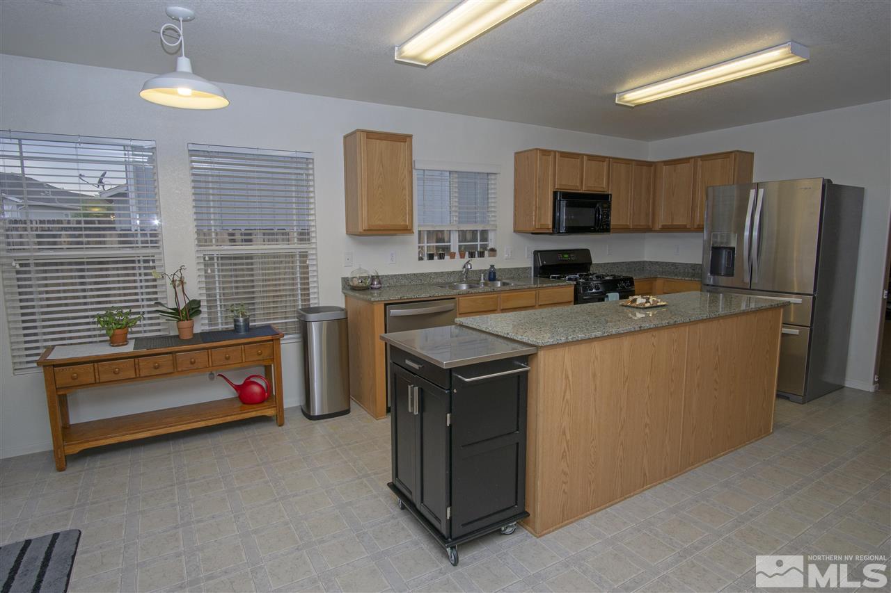 7692 Corso Street Reno, NV 89506 - Photo 8 of 23 a kitchen with refrigerator a stove a sink and a refrigerator