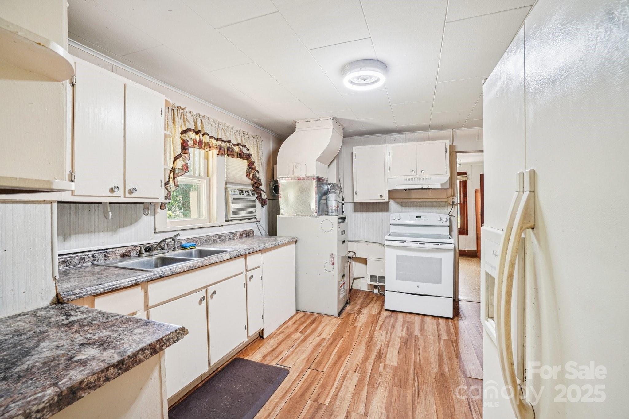 203 North Beaverdam Road Candler, NC 28715 - Photo 20 of 40 a kitchen with a sink stove and cabinets