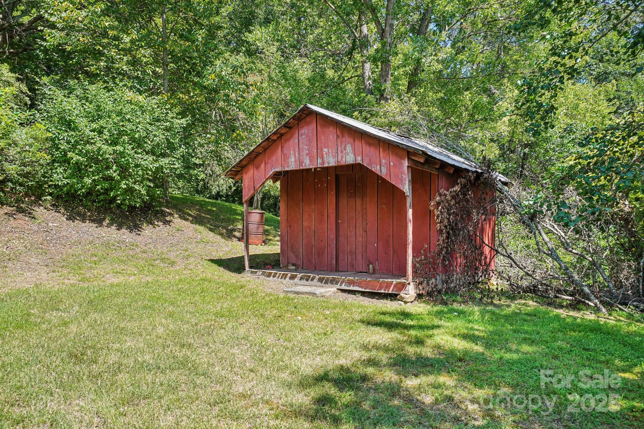 203 North Beaverdam Road Candler, NC 28715 - Photo 31 of 40 a view of barn with wooden fence and large trees
