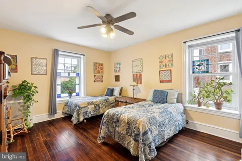 a bedroom with two beds and a potted plant