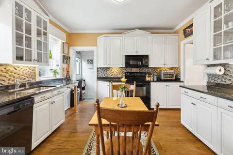 a kitchen with stainless steel appliances a stove a sink a microwave a refrigerator and cabinets